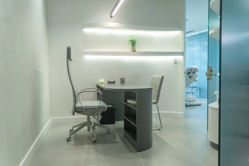 Private consultation room with ergonomic desk and direct access to treatment suite