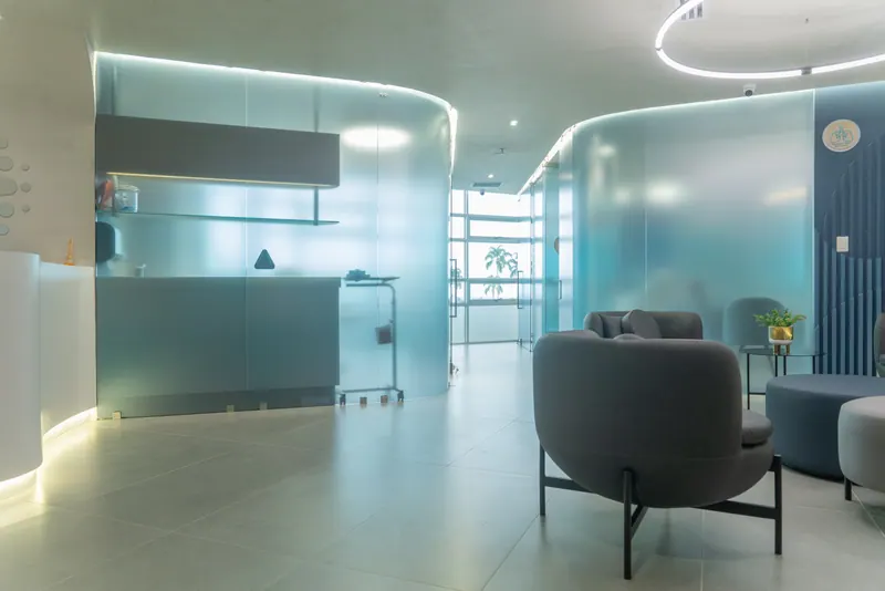Clinic lobby with teal frosted glass partitions and modern lounge seating